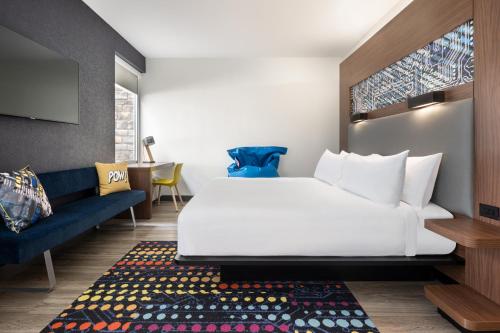a hotel room with a bed and a couch at Aloft Beachwood in Beachwood