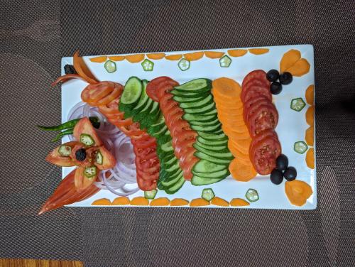 a plate of food with sausages and vegetables on it at Destination Hotel Khaplu in Khaplu