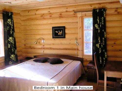 a bedroom with a bed in a log cabin at Spacious villa with great scenery and nature in Pertunmaa