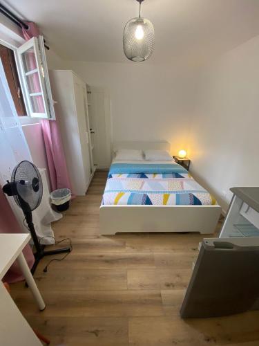 - une chambre avec un lit et un ventilateur dans l'établissement G-Logement-Francilien Goussainville CDG, à Goussainville