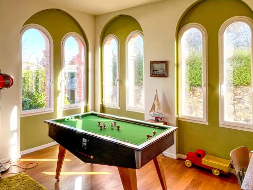a room with a pool table in a room with windows at Gai Séjour in Étables-sur-Mer