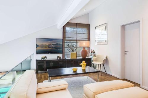 a living room with a couch and a table at Exquisite 5-Bedroom Villa in Arzier for Families by GuestLee in Arzier