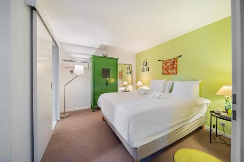 a bedroom with a white bed and a green door at Exquisite 5-Bedroom Villa in Arzier for Families by GuestLee in Arzier
