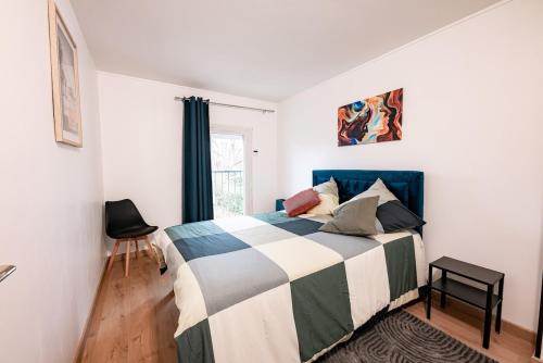 une chambre avec un lit avec une couverture bleue et blanche dans l'établissement Beautiful house near Disney for 12 people, à Champs-sur-Marne