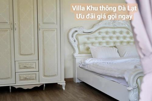 a bedroom with a white bed and a dresser at Chillin Villa - Biệt Thự Đà Lạt Khu Nhiều Thông Gần Hồ Tuyền Lâm in Xuan An