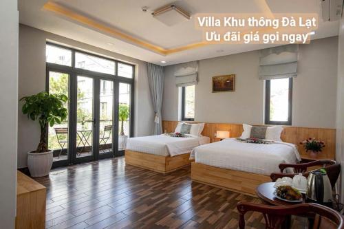 a hotel room with two beds and a table and chairs at Chillin Villa - Biệt Thự Đà Lạt Khu Nhiều Thông Gần Hồ Tuyền Lâm in Xuan An