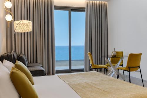 a hotel room with a bed and a view of the ocean at Mythical Coast Wellness Retreat in Mytilini