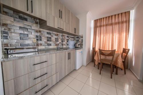 a kitchen with wooden cabinets and a table and chairs at Marina Apart Hotel in Marmaris