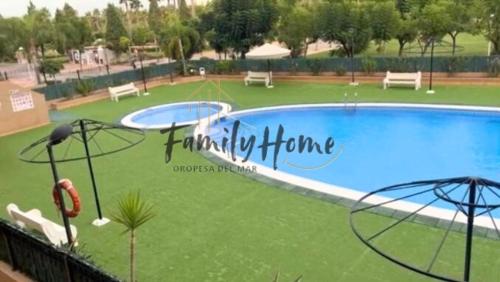 ein großer Pool in einem Park mit Bänken in der Unterkunft MAGNIFICO APARTAMENTO ATICO MARINA D'OR - COSTA CARIBE lll in El Borseral