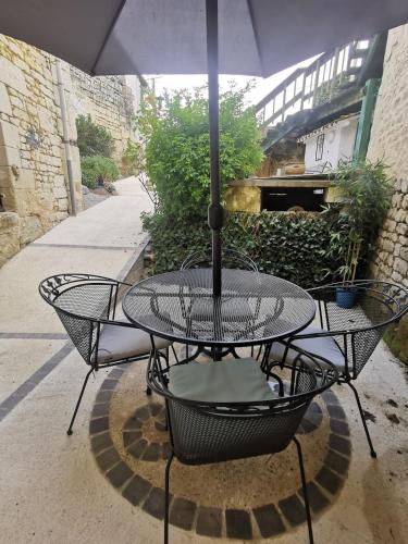 a table with an umbrella on a patio at Maison Troglodyte in Saint-Léger-de-Montbrillais