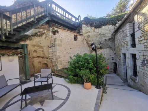 a patio with two chairs and a table in a building at Maison Troglodyte in Saint-Léger-de-Montbrillais