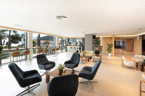 a waiting area in a hospital with chairs and tables at Calipolis in Sitges