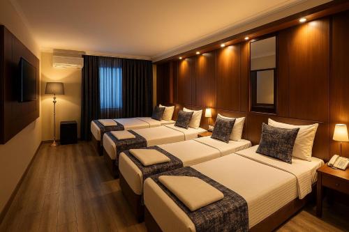 a hotel room with four beds and a telephone at Green Anka Hotel in Istanbul