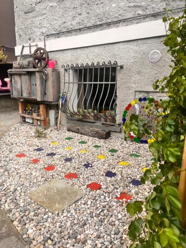 a garden with rocks and a fence and a table at Stanza in sondrio Coel in Sondrio