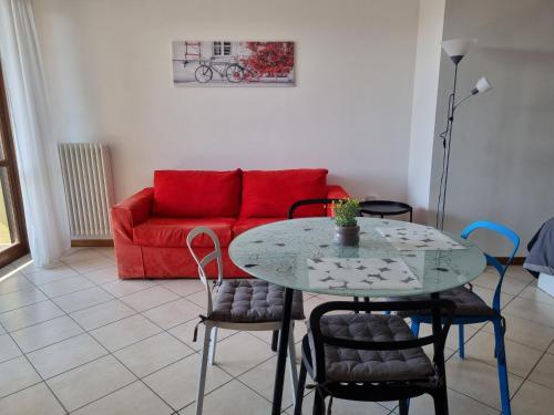 a living room with a table and a red couch at Studio with terrace in Busto Arsizio