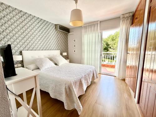 a bedroom with a bed and a television and a window at Casa Monte y Faro in Santa Pola