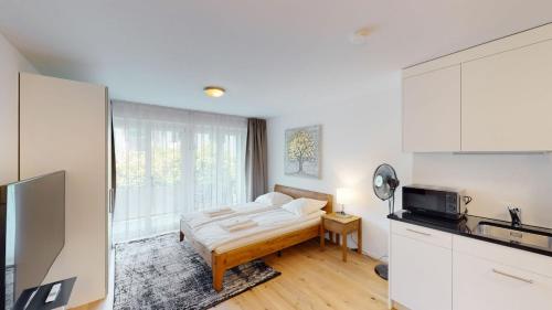 a living room with a bed and a kitchen at Cute and central studio - Sun 11 in Zurich