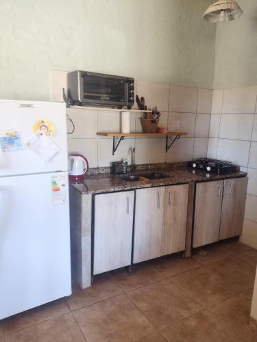 a kitchen with a white refrigerator and a microwave at Casa Munay in Uspallata