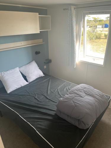 un lit dans une chambre avec une fenêtre dans l'établissement Camping 5étoiles, Torreilles Plage, à Torreilles