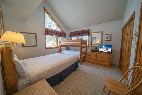 Un dormitorio con dos camas y un televisor. en Quicksilver 1618 by SummitCove Lodging, en Keystone
