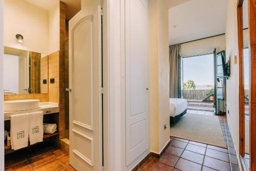 a bathroom with a sink and a bed in a room at Gran Claustre Boutique Hotel in Altafulla