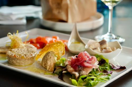 a plate of food with a salad and bread at Hotel Paradiso Conca d'Oro in Nago-Torbole
