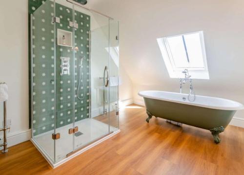 a bathroom with a tub and a glass shower at Vineyard View - Otium Wine Estate in West Worldham