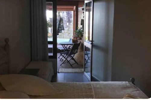 a bedroom with a bed and a balcony with a table at Casa da montanha Floripa in Florianópolis