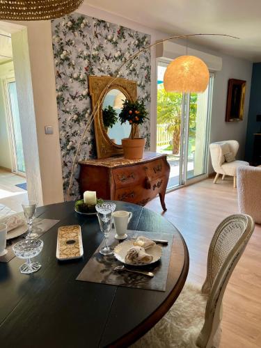 a dining room with a table and a mirror at SUITES EN PERCHE-Proche Mortagne in Bures
