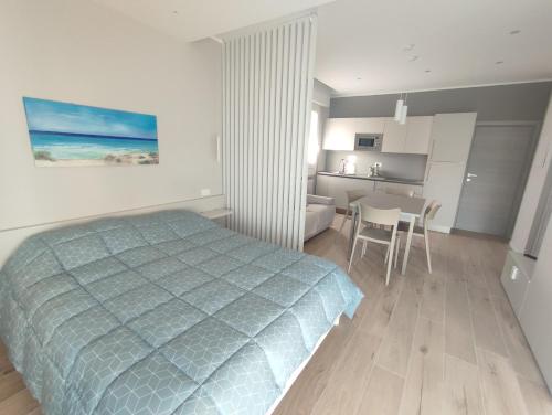una camera da letto con un letto, un tavolo e una cucina di Due passi dal mare a Bellaria-Igea Marina