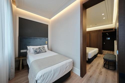 a hotel room with a bed and a mirror at Catalonia Plaza Catalunya in Barcelona