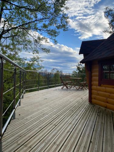 una gran terraza de madera con un banco. en Le Féérik, en Foncine-le-Haut