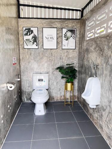 a bathroom with a toilet and a urinal and a sink at Baan Bua Homestay & Poolvilla in Ban Pa Mak (1)