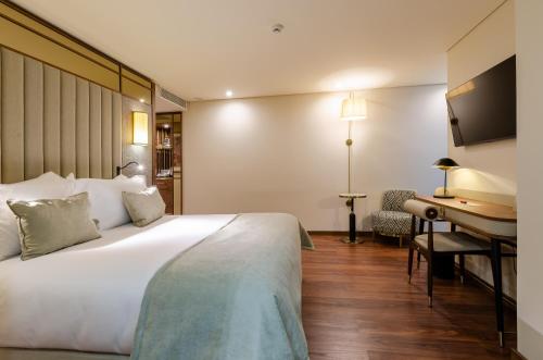 a hotel room with a large bed and a desk at TURIM Lisboa Hotel in Lisbon