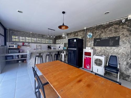 a kitchen with a wooden table and a counter at Baan Bua Homestay & Poolvilla in Ban Pa Mak (1)