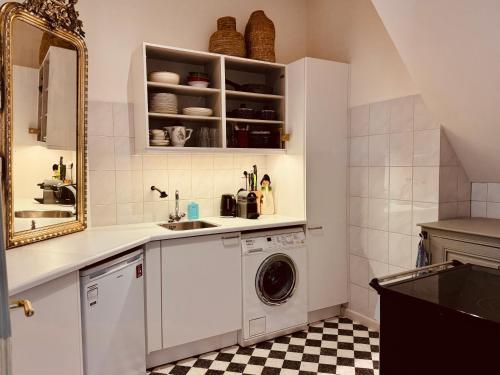 a kitchen with a washing machine and a mirror at Villa Abbekerk - Bed & Breakfast in Abbekerk