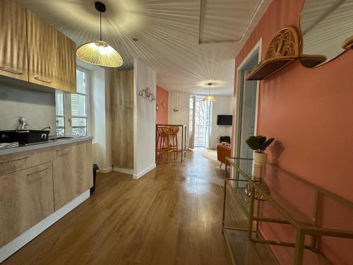 Il comprend une cuisine avec des murs orange et du parquet. dans l'établissement Charmant avec petit balcon au coeur du village, à Thurins