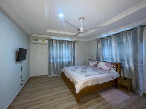 a bedroom with a bed and a ceiling fan at Sokea Safari Lodge And Suites in Kasoa