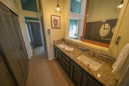 a bathroom with two sinks and a large mirror at Soda Spring 1917 by SummitCove Lodging in Keystone