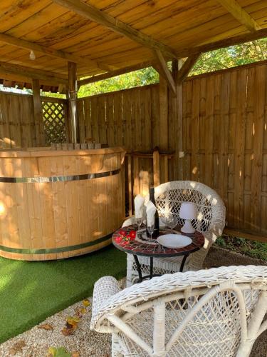 un patio avec une table et des chaises et une pergola en bois dans l'établissement cabane féérique, à Bégard