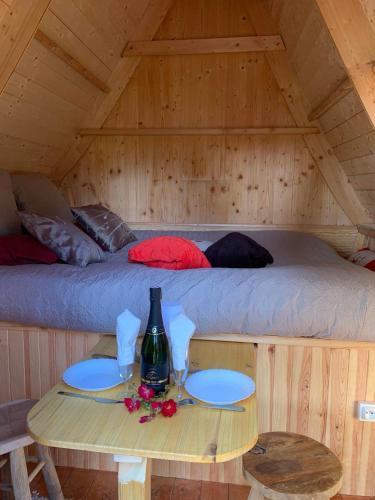 - une chambre avec un lit et une table dans une cabine dans l'établissement cabane féérique, à Bégard