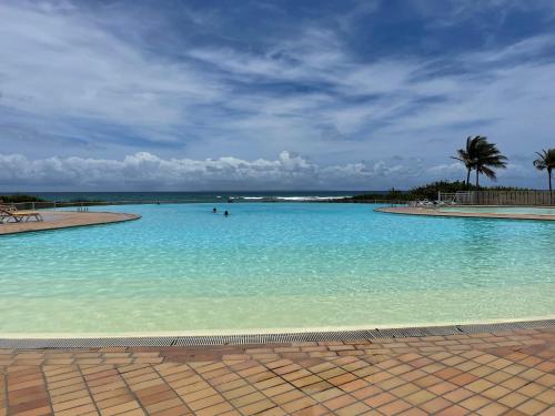 a large pool of blue water with people in it at Ti'Masani in Saint-François