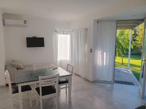 a white dining room with a table and chairs at Lo del Lolo GUALEGUAY in Gualeguay