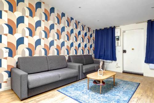 - un salon avec un canapé et un mur géométrique dans l'établissement Appartement elegant pour 6 pers au coeur de Paris, à Paris