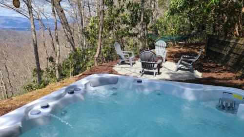a hot tub with two chairs and a table at SMOKY MOUNTAIN MAGIC-Spectacular Views, 3 Br, Sleeps 8, Hot Tub in Bryson City