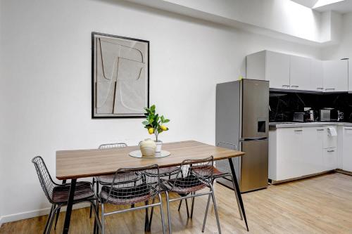 une cuisine avec une table, des chaises et un réfrigérateur dans l'établissement Appartement elegant pour 6 pers au coeur de Paris, à Paris