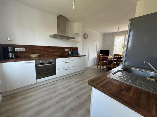 une cuisine avec des appareils électroménagers blancs et une salle à manger dans l'établissement Le Repaire de Plérin - Plage et bourg, à Plérin