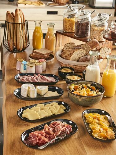 a table topped with lots of different types of food at Campanile NATURE - Mont de Marsan in Mont-de-Marsan
