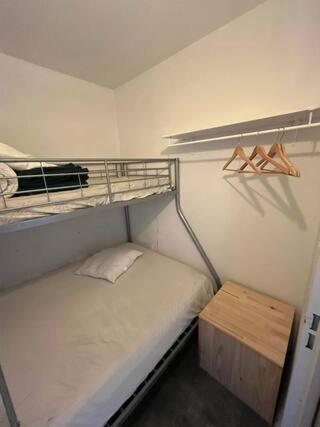 Cette petite chambre comprend des lits superposés et une table en bois. dans l'établissement Appartement Pied des pistes Vue sur les sommets, à Saint-Lary-Soulan
