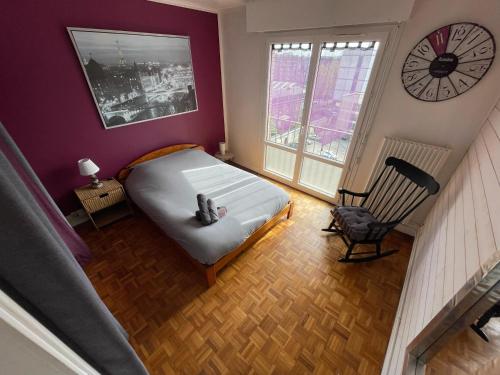 une chambre avec un lit et une horloge au mur dans l'établissement Parenthèse de Calme - 380, à Rouen